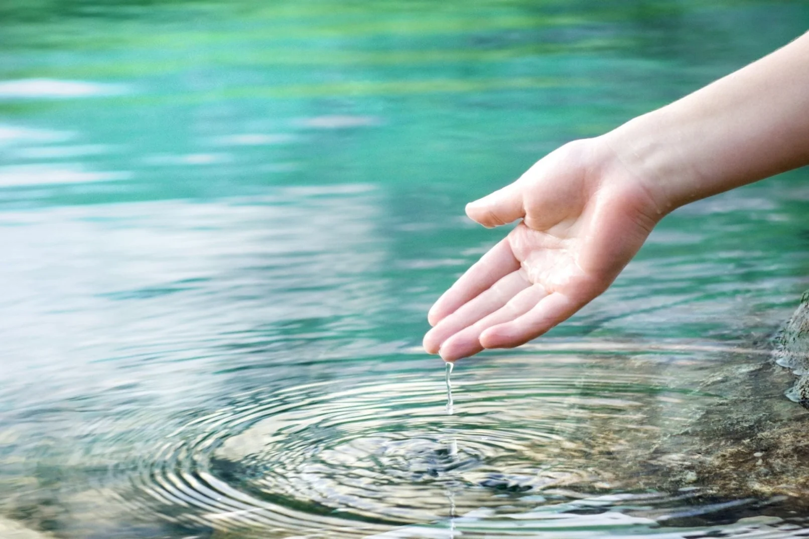 Hand gently touching calm water