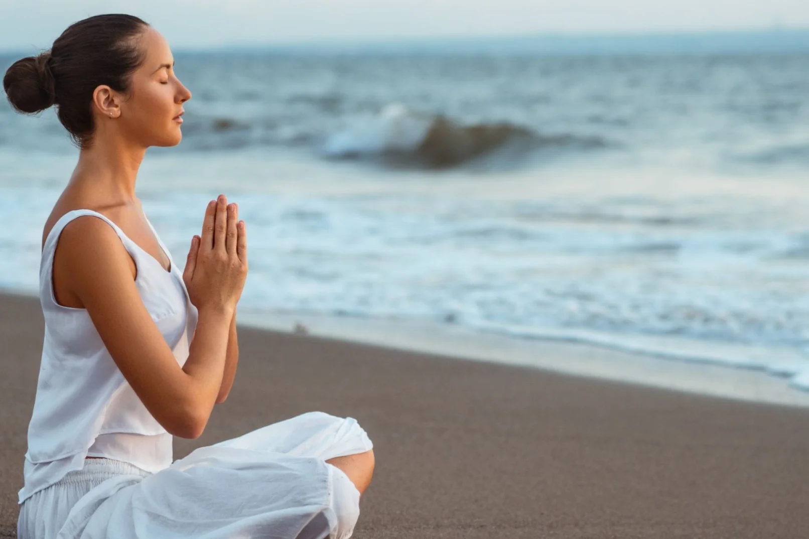 Woman meditating on the beach